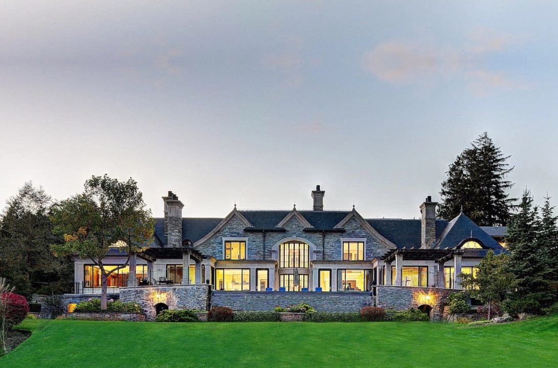 Stone estate home with manicured front lawn